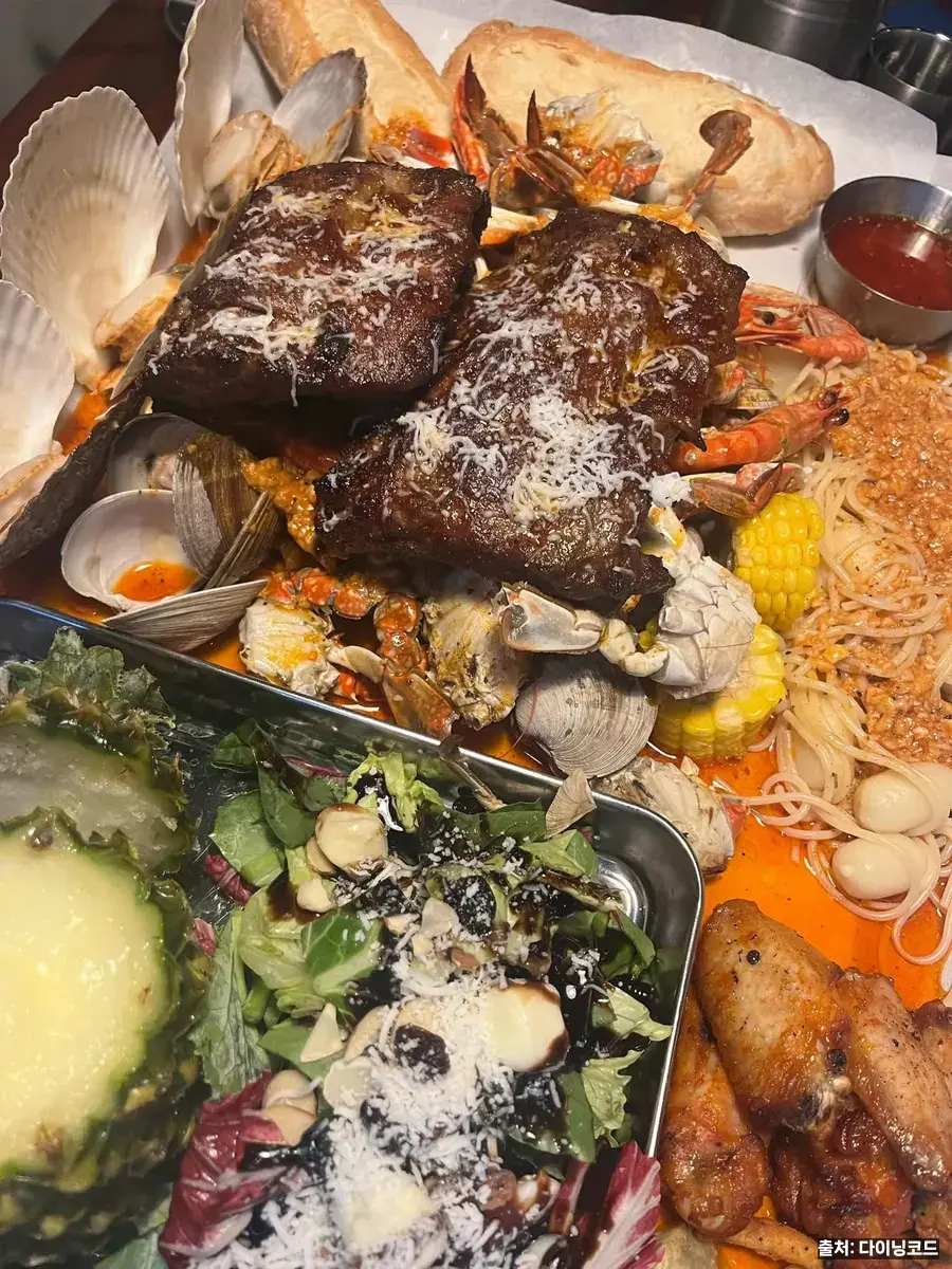 저녁 메뉴 못 정하는 사람을 위한 송도 타임스페이스 맛집 6곳 2 더매드 송도 타임스페이스의 씨푸드 보일링 한 상, 립과 대게살 조개 옥수수 파스타면이 함께 담긴 모습