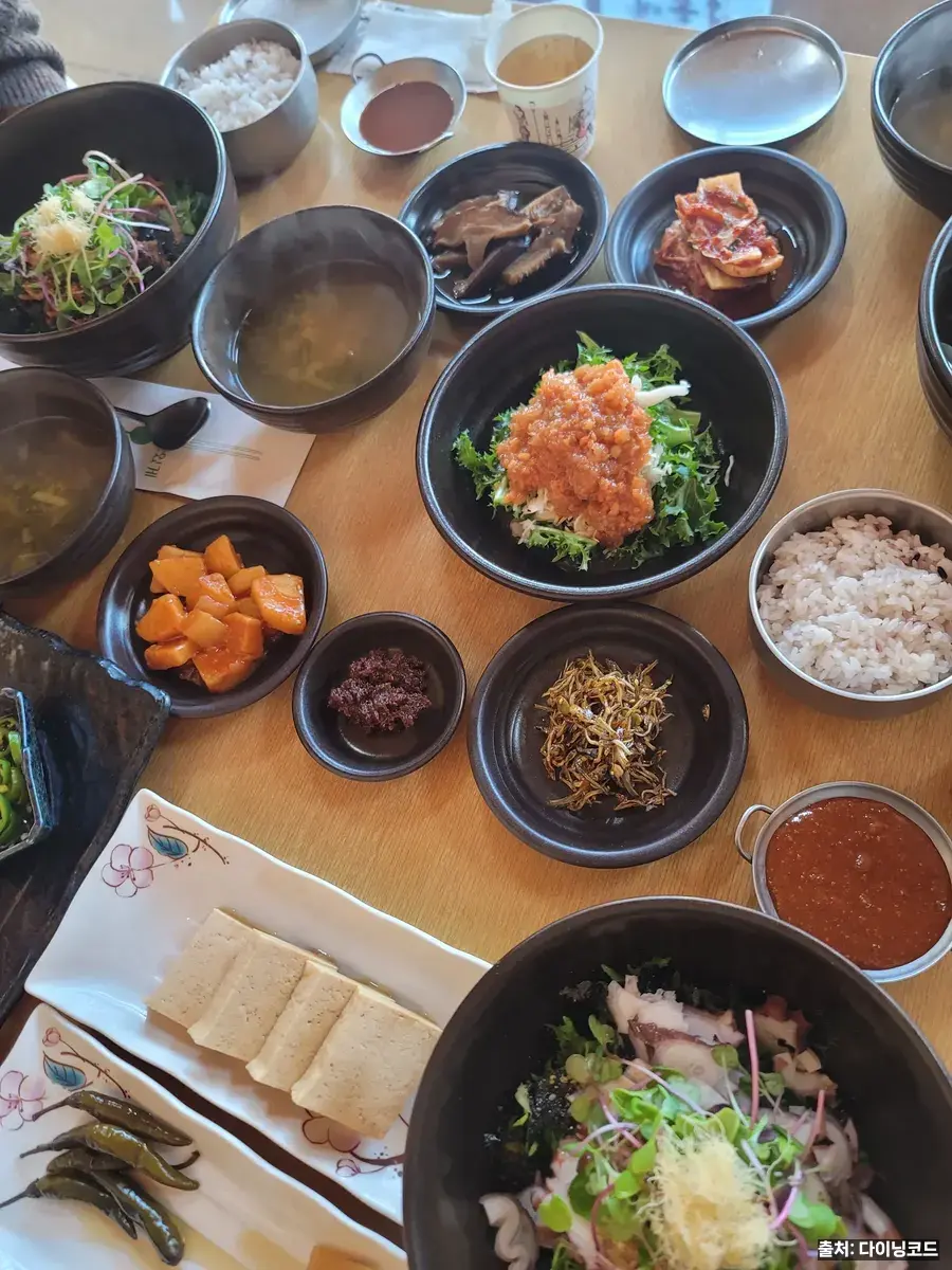 경춘재 한상차림, 명란 샐러드와 잡곡밥·반찬이 검은 그릇에 담긴 모습
